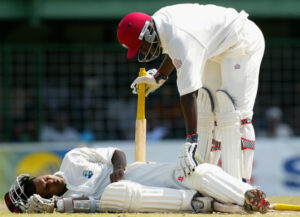 Shivnarine Chanderpaul winces in pain on the ground after a ball from Andy Bichel hit his knee © Getty Images