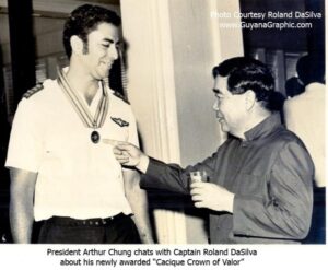 President Arthur Chung chats With Captain Roland DaSilva about his "Cacique Crown of valor"