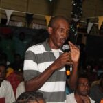 Mahdia residents and miners listen as Mahdia resident, Pastor Michael Matterson, voices his concerns to the Ministers