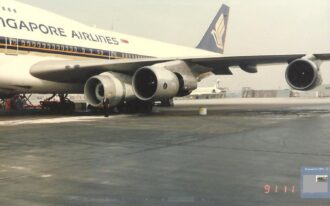 Captain Michael Paheco stands beneath the wing of the Boeing 747-400 near the engine pod used to transport  the engine that had exploded during takeoff from Los Angeles. The engine had been secured for transport to Singapore.